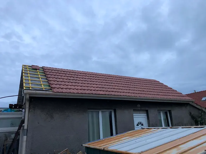 Repose des tuiles neuves sur la moitié de la toiture