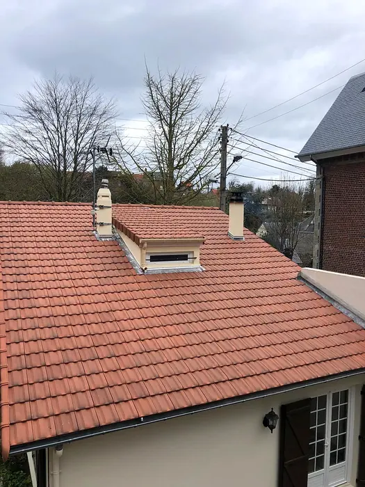 Toiture en tuiles neuves terminée avec sa lucarne