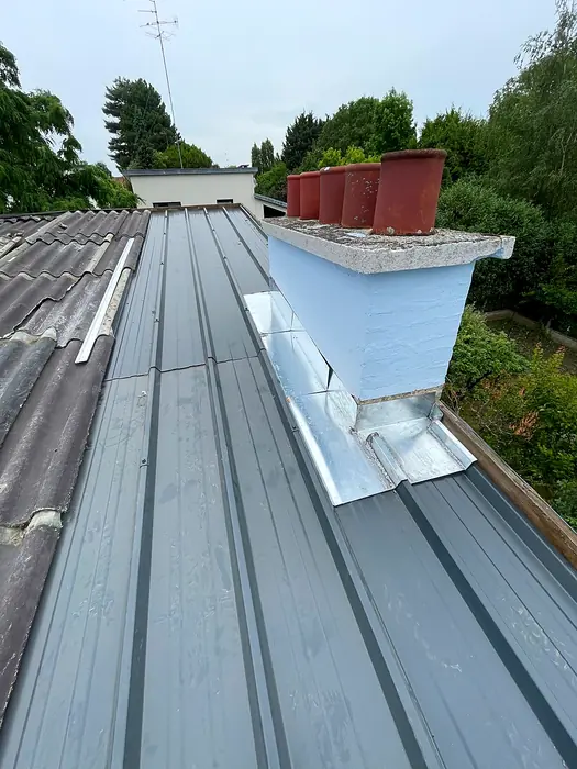 Toiture en bac acier avec souche de cheminée et solin en zinc