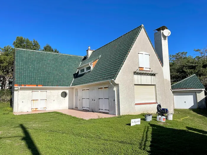 Maison avec toiture verte et façade grise avant travaux