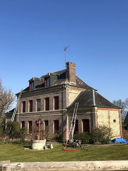 Maison de maître en brique avec toiture ancienne et échelles installées